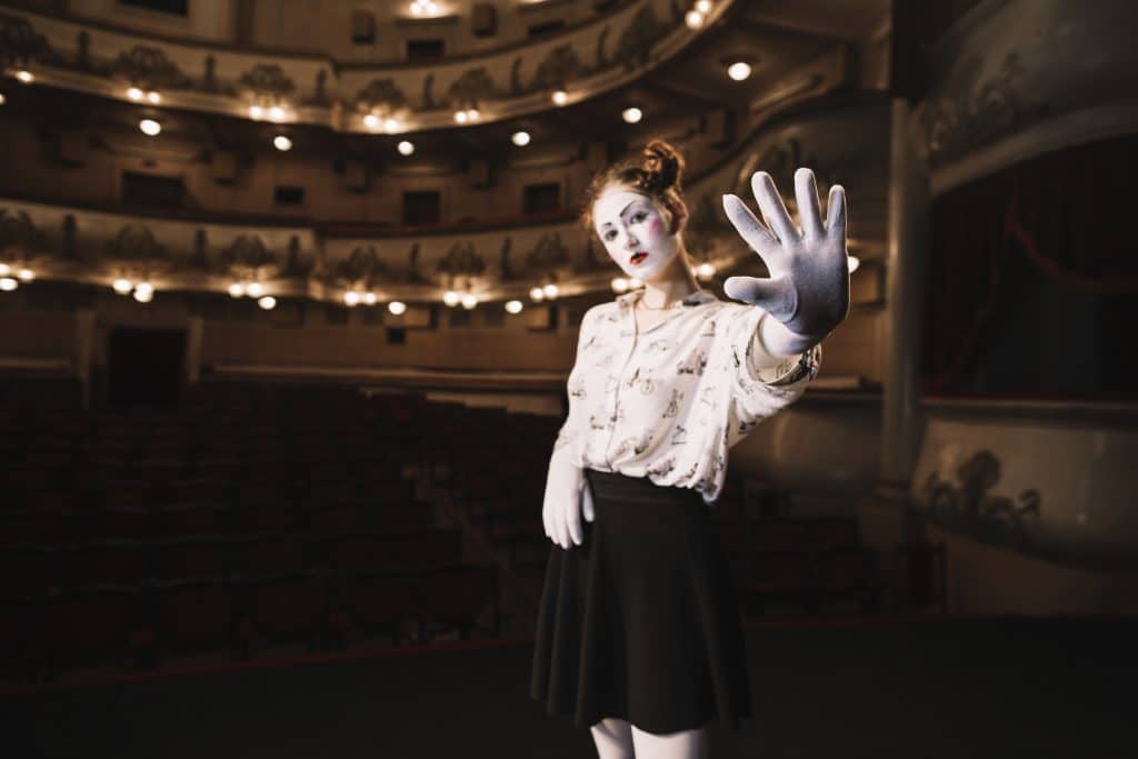 Female mime standing auditorium showing stop gesture